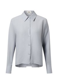 Light blue button-up shirt made of textured fabric, featuring a pointed collar and long sleeves with a slightly curved hem.