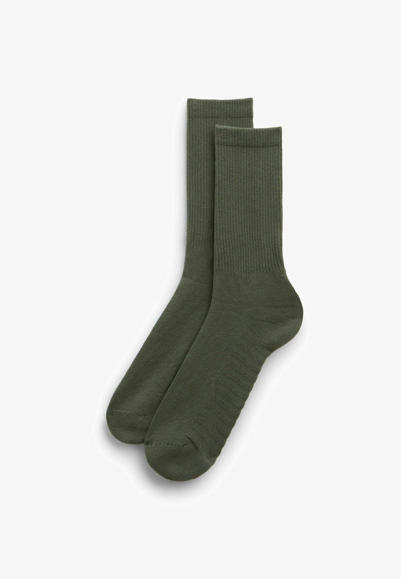 Paire de chaussettes mi-hautes vert olive avec texture côtelée sur les jambes et zone lisse au niveau du pied, étalées à plat sur un fond blanc.