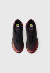 Črne atletske čevlje z gradientnim iridescentnim vzorcem, ki vključujejo teksturirano mrežasto zgornji del, okrogle vezalke in vidno Air Max oblazinjenje v podplatu.