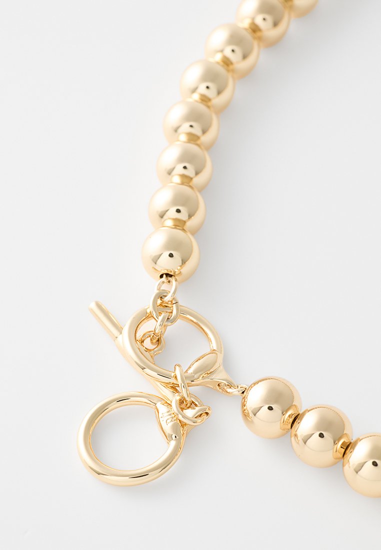 Collana con perline in tono dorato, caratterizzata da perle sferiche lucidate, chiusura a gancio e una superficie liscia.