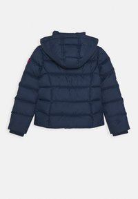 Giacca puffer blu navy con cappuccio, caratterizzata da un design a trapunte, polsini elasticizzati e un dettaglio accentuato sulla spalla sinistra.