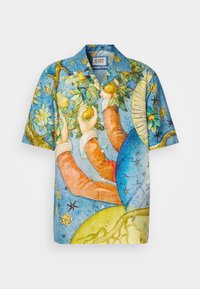 Camisa de manga corta con un vibrante patrón de acuarela azul que presenta manos, frutas y motivos celestiales. Fabricada con tejido ligero.