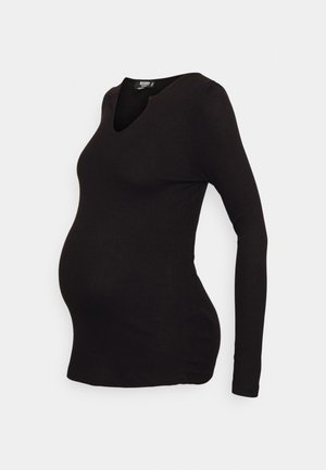 Blusa de maternidade de manga longa preta, feita de tecido canelado, com decote em V e um design justo que acomoda uma barriga em crescimento.