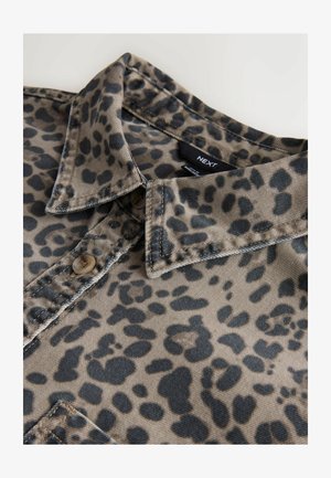 Leopardi mustriga särk, millel on beež taust mustade laikudega, nööbiga sulgemine ja volditud krae. Materjal näib olevat tekstuuriga, tõenäoliselt puuvill.