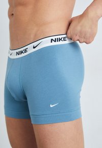 Boxers ajustados en color azul de Nike, con un logo negro en la cinturilla blanca. Material de algodón suave, diseño ceñido y longitud a mitad del muslo.