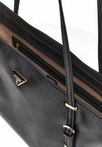 Borsa a tracolla nera in pelle con finitura testurizzata, manici superiori e una patch logo in hardware dorato. L'interno include tasche con zip e tasche a scomparsa.