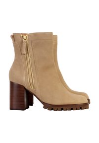 Stivali ankle in suede beige con una finitura texturizzata, dotati di una cerniera laterale dorata e un robusto tacco in legno. Dettaglio della suola resistente evidente.