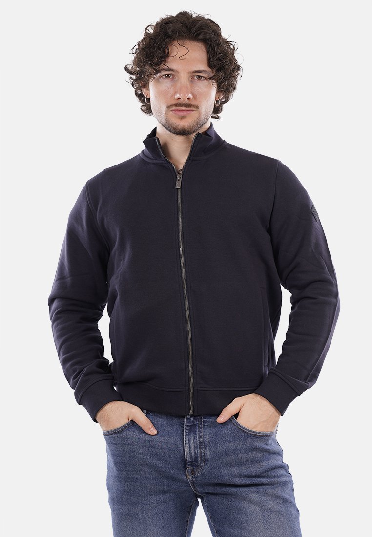 Felpa con zip color navy, collo alto, texture morbida, polsini e vita a costine; dotata di tasche laterali e logo del brand discreto sulla manica.