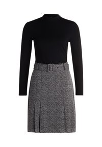 Haut noir à manches longues associé à une jupe grise à motifs avec une ceinture, des plis et un design texturé.