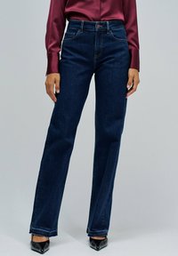 Jeans rectos de color azul oscuro, confeccionados en denim, con un diseño clásico de cinco bolsillos y un cierre de botón en la parte delantera.