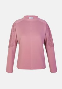 Rosa bluse med høy hals, lange ermer og blondeakkenter på skuldrene. Laget av glatt stoff med en tettsittende fasong.
