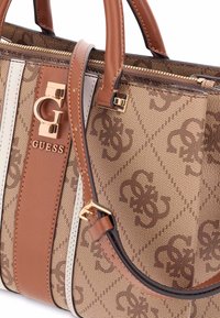 Bolso marrón fabricado con material sintético estampado y acentos en beige y blanco. Presenta herrajes con logo, forma estructurada y asas dobles.
