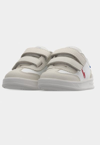 Λευκά και ανοιχτό γκρι παιδικά αθλητικά παπούτσια με λουράκια βέλκρο και κόκκινο λογότυπο παίκτη πόλο στο πλάι, εμφανιζόμενα από την μπροστινή γωνία.