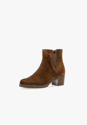 Stivaletto in suede marrone con tacco basso a blocco, pannelli laterali elastici e una texture liscia. Presenta una punta arrotondata e dettagli di cucitura.