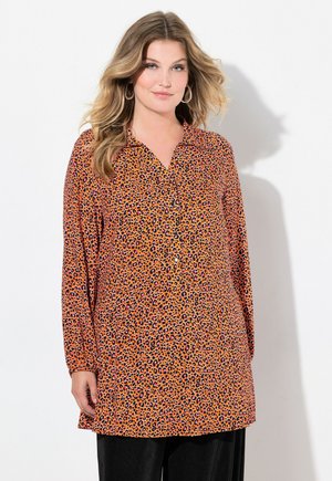 Tunique à imprimé léopard en orange avec des accents noirs et roses, dotée d'un col, de manches longues et de détails de fermeture à boutons.