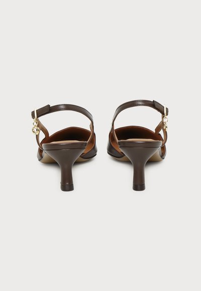 Par mørkebrune slingback kitten heel-sko med liten gullanheng på ankelsrem, vist bakfra på hvit bakgrunn.