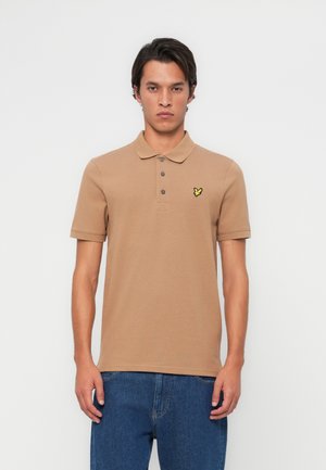 Polo shirt beige avec col et patte de boutonnage à trois boutons. Doté d'un petit logo de papillon jaune sur la poitrine gauche. Tissu doux, manches courtes.