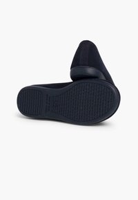 Chaussures noires à enfiler avec une tige en tissu doux, bout rond, semelle en caoutchouc plate dotée d'une texture antidérapante et un talon rembourré pour le confort.