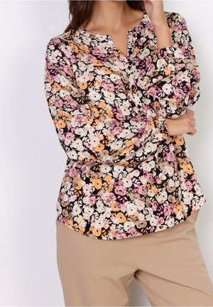 Blumenbluse in Schwarz, mit einer Vielzahl von pastellfarbenen Blumen in Rosa, Orange und Weiß. Weicher Stoff mit lockerer Passform und Knopfdetails.