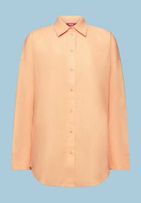Chemise à manches longues couleur pêche avec boutons, col classique, design simple et ourlet arrondi sur un fond bleu clair.