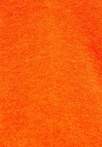 Leuchtend orangefarbener gestrickter Stoff, der eine strukturierte Oberfläche mit einem gleichmäßigen Stichmuster und leichten Farbintensitätsvariationen aufweist.
