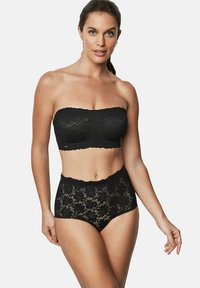 Zwarte kanten bandeau-top met gegolfde randen, gecombineerd met hoge zwarte kanten slips met bloemenpatronen en een gladde textuur.
