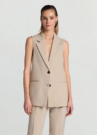 Blazer sans manches beige avec un col cranté, deux poches avant, des boutons noirs uniques et une texture de tissu lisse.