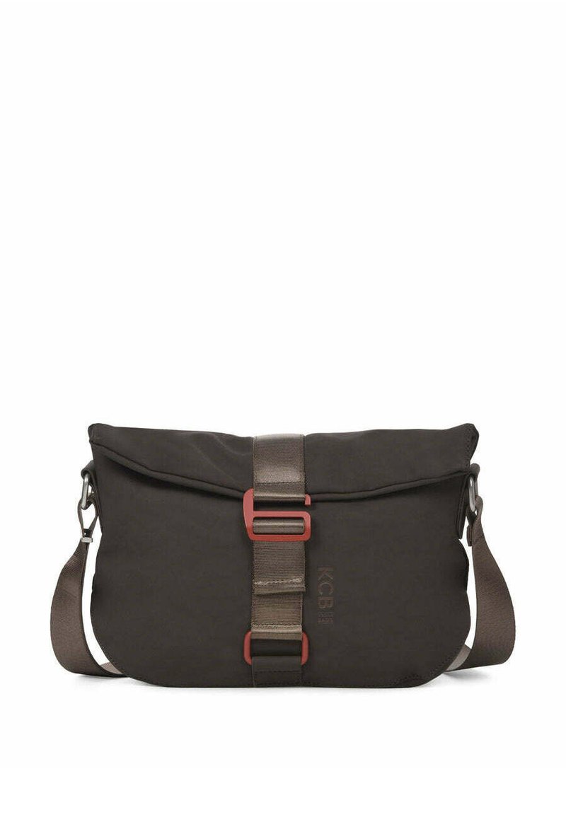 Bolso tipo mensajero de color marrón oscuro hecho de tela duradera. Cuenta con una solapa frontal, una correa de tela y herrajes en rojo como acento, con un cierre seguro.