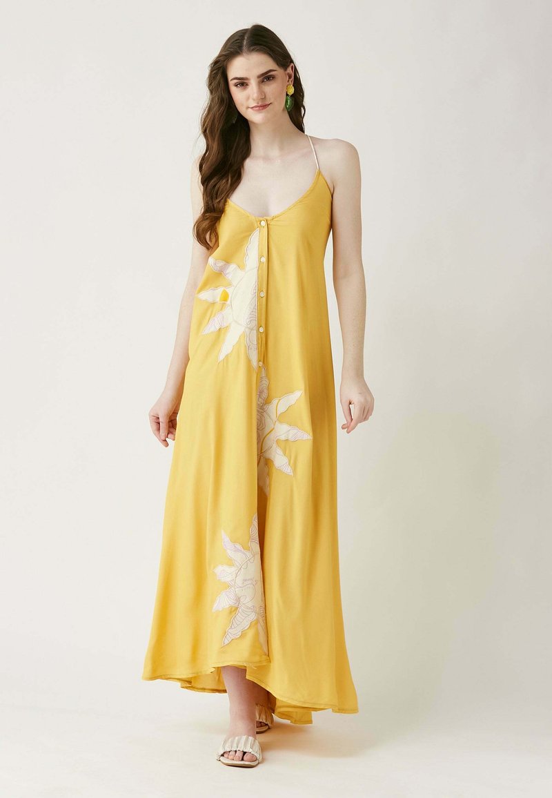Gelbes Maxikleid mit V-Ausschnitt, mit Knopfdetails entlang der Vorderseite und weißen botanischen Drucken, aus leichtem Stoff gefertigt.