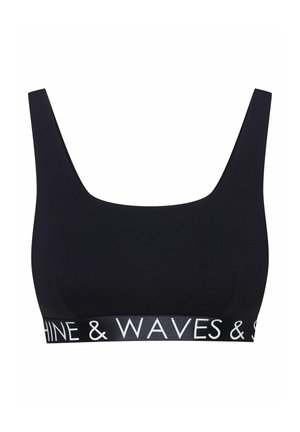 Schwarzer Bralette mit breiten Schulterträgern und herzförmigem Ausschnitt. Mit einem kontrastierenden weißen Logo-Band am unteren Rand. Glatte Stofftextur.