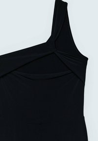 Robe noire sans manches avec bretelles asymétriques et détail d'un nœud torsadé au niveau de l'encolure sur un fond clair uni.
