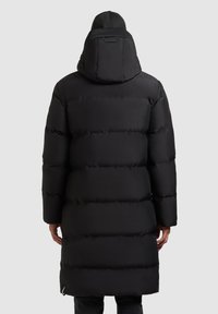 Sort puffjakke med aftagelig hætte, der har et quiltet design, lange ærmer og en mellemlang længde. Glat tekstur og subtil branding.