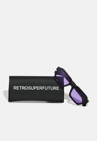 Fekete napszemüveg téglalap alakú kerettel és lila lencsékkel, egy hozzá illő fekete tok mellett kiemelve, amelyen fehér betűkkel szerepel a "RETROSUPERFUTURE" felirat.