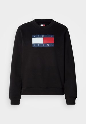Sweatshirt preto com gola redonda, apresentando um logótipo retangular em azul, vermelho e branco que diz "TOMMY JEANS." Textura suave, ajuste casual.