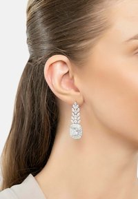 Silver-tone drop earrings featuring a rounded center stone with a rectangular cut, surrounded by marquise and teardrop accents.