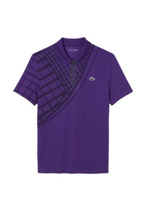 Polo shirt violet avec col zippé, manches courtes et un motif géométrique dans un violet plus foncé d'un côté. Logo Lacoste affiché.