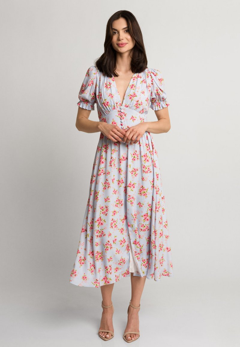 Jasnoniebieska midi sukienka w kwiatowy wzór w odcieniach różu i zieleni. Posiada bufiaste rękawy, głęboki dekolt w serek i rozcięcie, wykonana z miękkiego materiału.