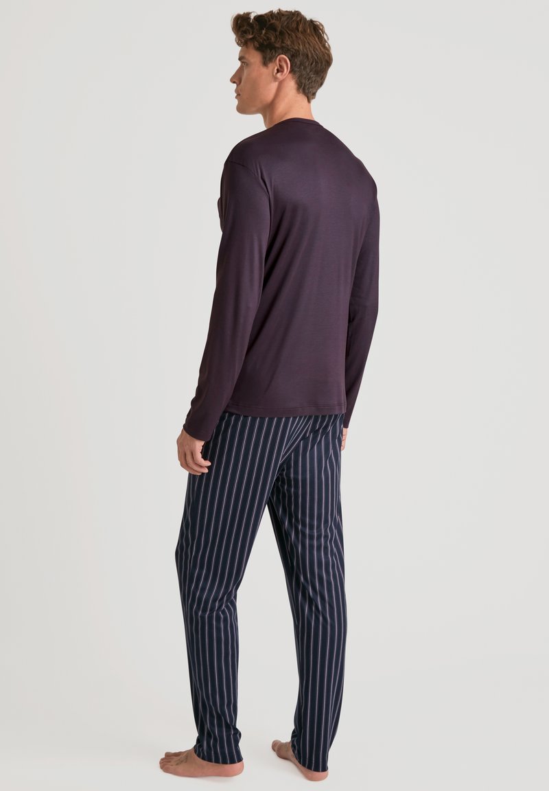 Haut à manches longues de couleur violet foncé associé à un pantalon de pyjama rayé bleu marine et blanc. Le tissu semble doux, avec une coupe décontractée et un design léger.