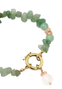 Grönt ädelstensarmband med oregelbundet formade stenar, ett runt guldspänne och rosa samt vita pärldetaljer.