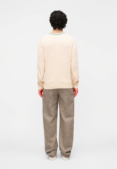 Helebeež kampsun soonikkoelise krae ja varrukasäärtega, ühendatud lahtiste, tekstuursete pruunide pükstega. Lihtne disain, nähtamatute mustriteta.