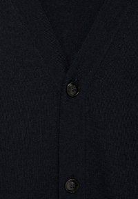 Námořnický pletený cardigan s designem V, se dvěma černými knoflíky vpředu, který zdůrazňuje texturovanou, měkkou látku.
