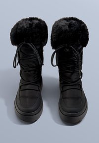 Schwarze, wattierte Winterstiefel mit Kunstfellbesatz, dekorativer Schnürung und dicken Gummisohlen für besseren Halt. Glatte, matte Oberfläche.