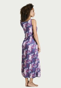 Robe maxi florale en violet, ornée de fleurs blanches et roses avec des accents verts, design sans manches, tissu doux et coupe ample.