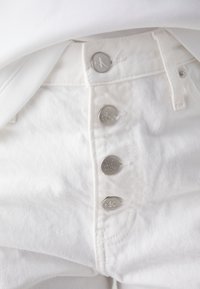 Bílé džíny z denimu s stříbrnými logovými knoflíky a hladkou texturou, s vysokým pasem a bočními kapsami.