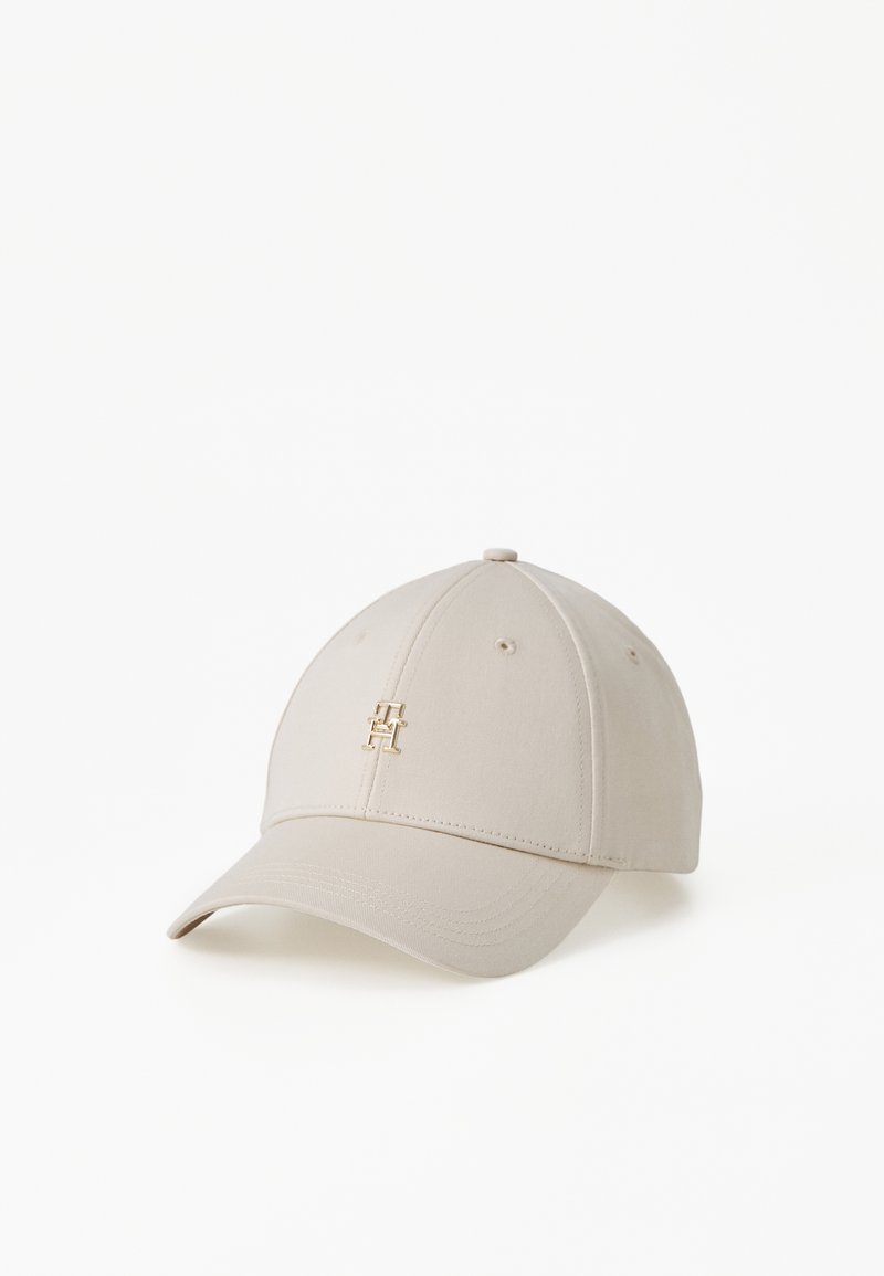 Casquette de baseball beige avec un logo doré sur le devant, design structuré, visière incurvée et détails brodés sur la couronne.