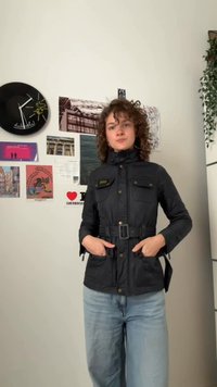 Fekete steppelt dzseki magas gallérral, övvel ellátott derekkal, két mellzsebbel és két elülső zsebbel. Aranyszínű fém kiegészítőkkel.