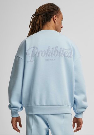 Light blue oversized sweatshirt made of soft fabric, featuring "Prohibited" graphic and ribbed cuffs, with a relaxed fit and crew neckline.