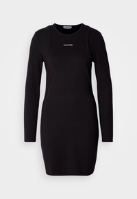 Juoda ilgarankovė suknelė, pagaminta iš glotnios medžiagos, su apvalia iškirpte ir subtiliu Calvin Klein logotipu ant krūtinės. Kūną atitinkanti forma.