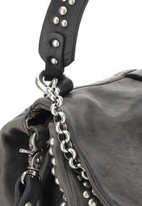 Zwarte leren handtas met zilveren studs en kettingaccenten, voorzien van een dikke schouderband en een metalen sluiting. Textuur van het oppervlak is zichtbaar.