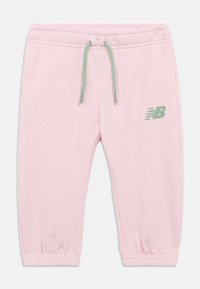 Lichtroze peuter joggingbroek met elastische boorden, groene trekkoord, zijzakken en groen New Balance-logo op de linker dij.